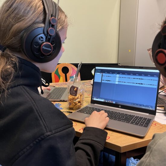 2 Kinder beim Edieren einer Audioaufnahme vor dem Computer